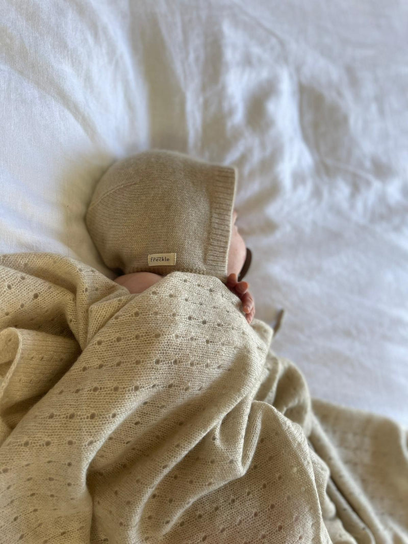 The cutest soft knit cashmere bonnet , made to keep your little ones warm. Tie to fasten under the chin. Pair with one of our All-in One Cashmere Bodysuits.   Comes in a white Gift Box 100% Designer baby Cashmere Colour - apricot ivory 